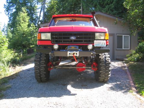 1989 Ford Bronco - Modified red 1987 Ford Bronco with off-road equipment parked in a driveway.