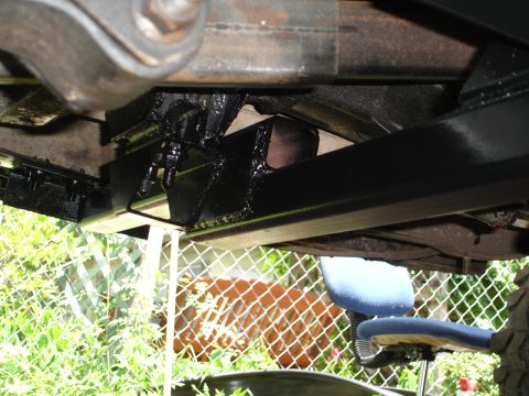 1989 Ford Bronco - Close-up of the vehicle's undercarriage, focusing on the frame and a black crossmember.