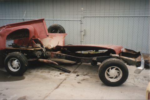 1967 Ford F-100 - Side view of a wrecked 1967 Ford F-100 truck chassis, showing the damaged cab and bed.