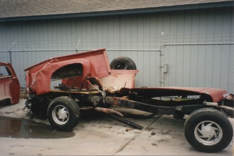 1967 Ford F-100 - This heavily damaged pickup truck chassis sits in a yard, stripped of its cab and bed.