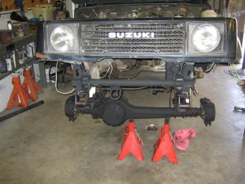 1987 Suzuki Samurai - Front axle assembly of a 1987 Suzuki Samurai, removed and supported by jack stands.