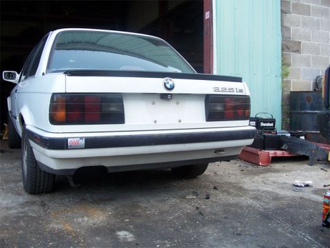 1989 BMW 3 Series - Rear view of a white 1989 BMW 3 Series sedan with a spoiler and 325is badging.