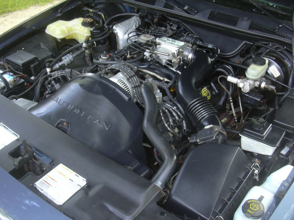 Engine bay with 'CAUTION FAN' visible on fan shroud