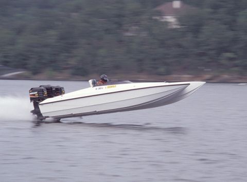 2001 Ford F-250 - A white speedboat with twin outboard engines cuts through the water, with a driver visible at the helm.