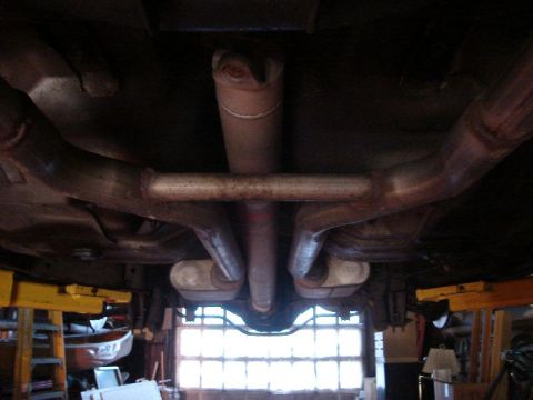 1992 Ford Crown Victoria - The underside of a vehicle shows its dual exhaust system and driveshaft, viewed from below.
