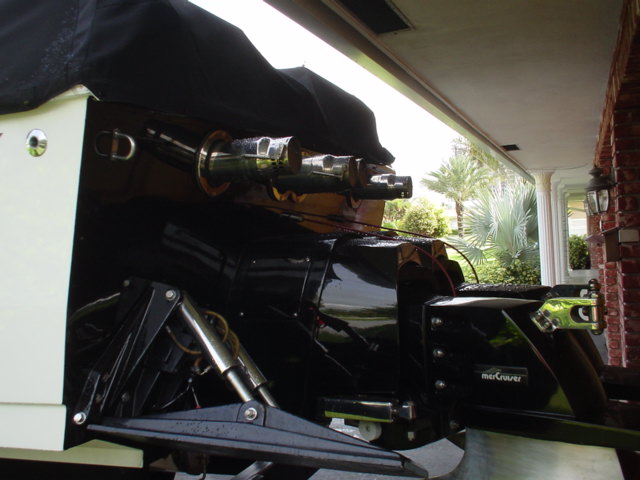 Black MerCruiser sterndrive on the transom of a white boat parked under a carport