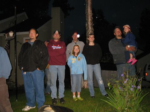 2000 Ford E350 - Several people gathered outdoors at night, with a white van partially visible in the background.