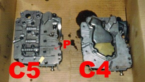 1992 Ford Explorer - Comparison of two transmission valve bodies, one labeled C5 and the other C4, with a pointer on the C5 unit.