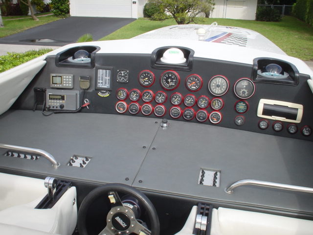 Boat dashboard with many gauges, radio, and steering wheel