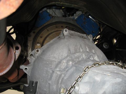 1973 Ford Ranchero - Close-up view of a transmission bell housing and flywheel, with a blue engine block in the background.