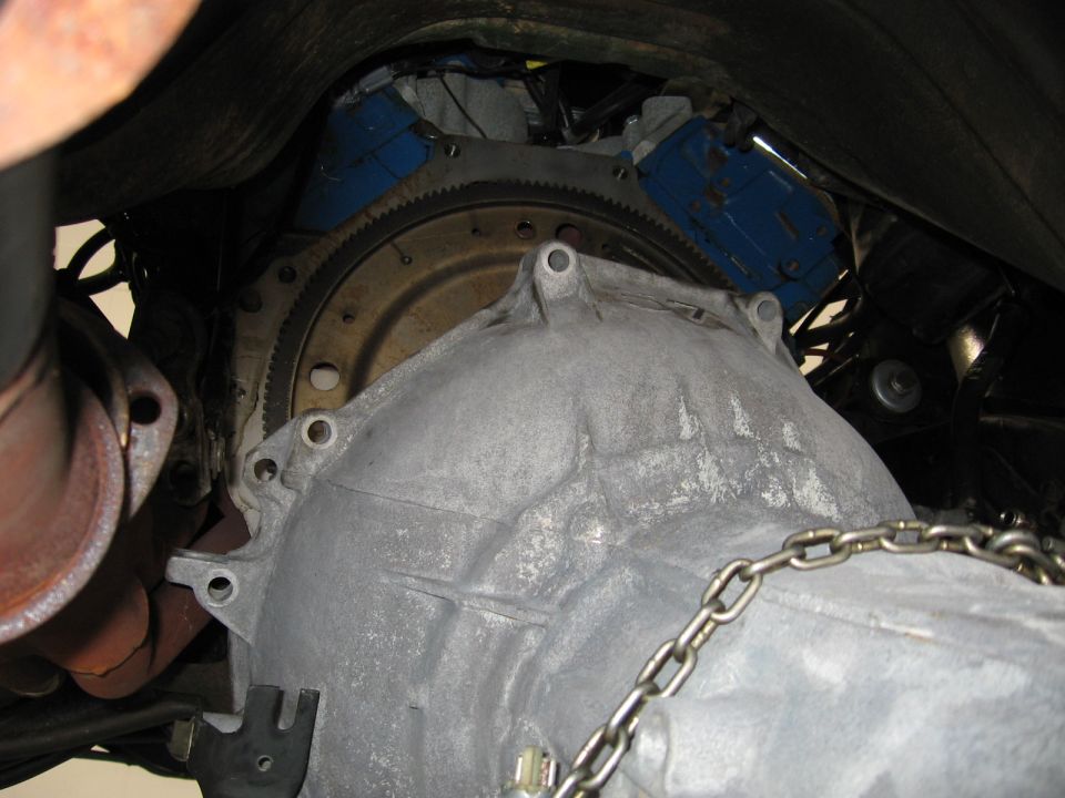 Transmission bell housing and flywheel with blue engine block visible