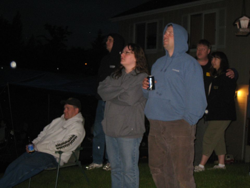 Group of people watching an outdoor event at night
