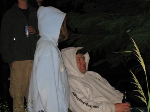 2000 Ford E350 - Outdoor gathering at night with people wearing hoodies and holding drinks.