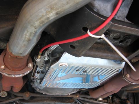 1973 Ford Ranchero - Chrome transmission pan and exhaust system components viewed from underneath a vehicle.
