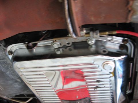 1973 Ford Ranchero - Close-up view of a chrome transmission pan and its associated linkage mechanism.