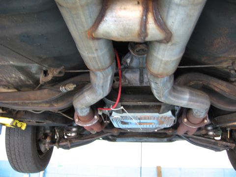 1973 Ford Ranchero - The underside of a vehicle reveals its exhaust system and transmission components.