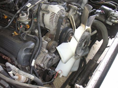 1997 Ford Crown Victoria - Close-up view of a dusty engine bay, showing various mechanical components.