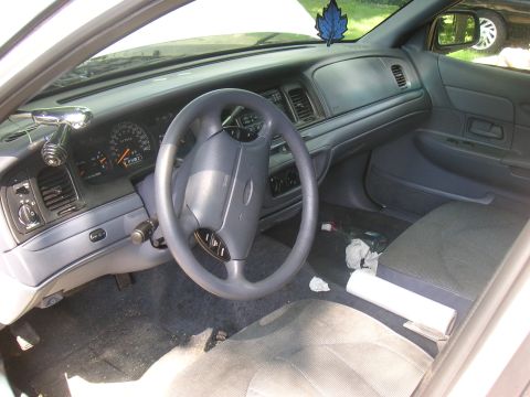 1997 Ford Crown Victoria - The interior of a car is shown, the dashboard, steering wheel, and seats. A watermark for SuperMotors is visible at the bottom right.