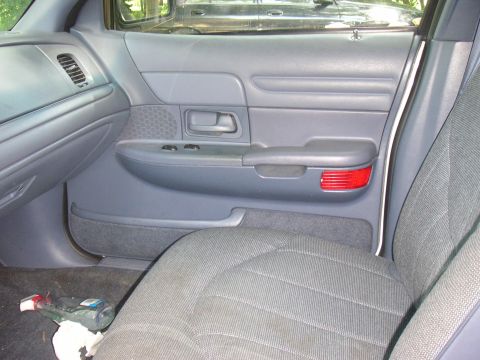 1997 Ford Crown Victoria - Interior view of a gray door panel and seat, a red reflector. This appears to be a 1997 Ford Crown Victoria.
