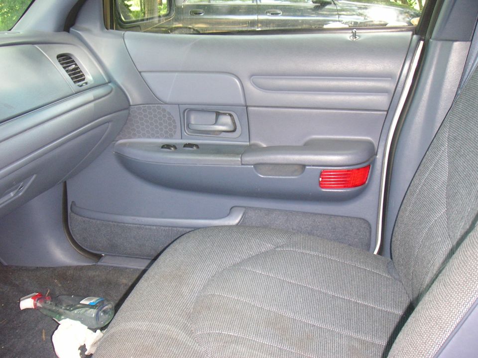 Gray interior door panel with red reflector and fabric seat. 1997 Ford Crown Victoria