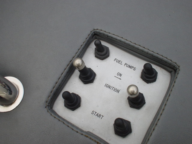 White switch panel with six toggles labeled FUEL PUMPS, IGNITION and START on gray dash