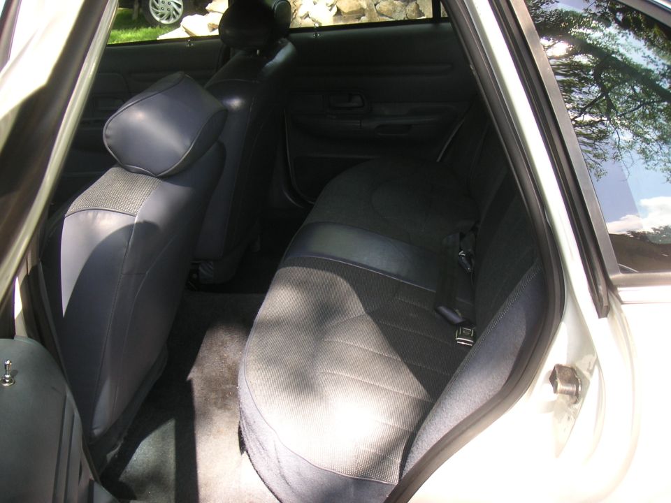 Back seat and door panel of a car. Blue fabric seats and dark interior