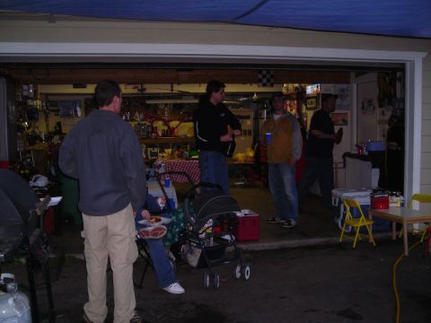 2003 Jeep TJ - A group of people gather in a garage during a party, with a stroller and various items visible.
