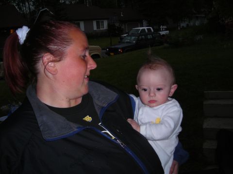 2003 Jeep TJ - Woman holding a baby with a mohawk hairstyle outdoors.