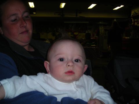 2003 Jeep TJ - A woman holds a baby in a dimly lit indoor space with some items visible in the background.