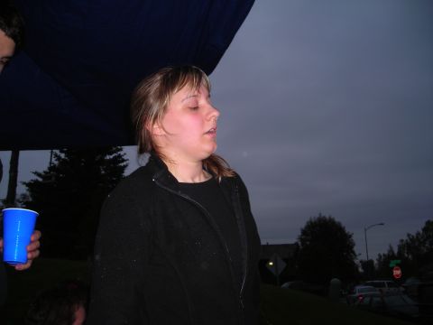 2003 Jeep TJ - Woman holding a blue cup at an outdoor gathering under a dark sky.