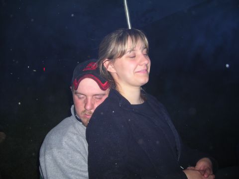 2003 Jeep TJ - A couple shares a moment together in the darkness, possibly at an outdoor event.