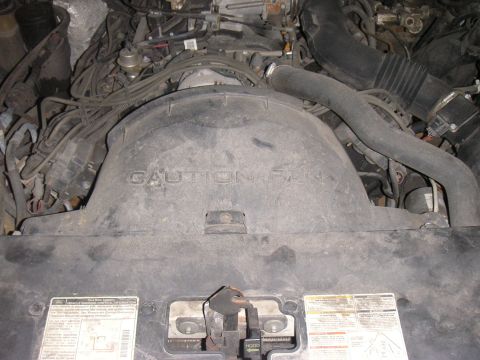 1997 Ford Crown Victoria - The image shows a close-up of a vehicle's engine bay, focusing on the fan shroud with visible warning text.
