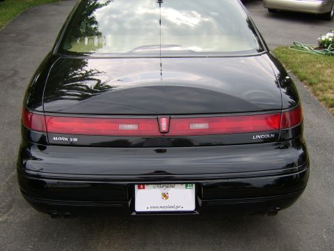1996 Mercury Grand Marquis - Rear view of a black Lincoln Mark VIII, showing the taillight bar and trunk badging.