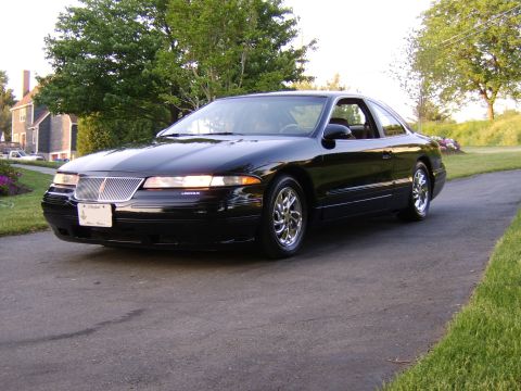 1996 Mercury Grand Marquis - Black Lincoln Mark VIII coupe with chrome wheels is shown from a 3/4 front angle.