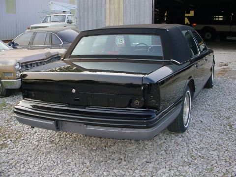 1972 Ford Ranchero - Black sedan with a vinyl roof parked outdoors. Another vehicle is partially visible to the left.