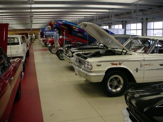 White 1962 Ford Galaxie with 'Honey Up' on door, parked in a line with other classic cars
