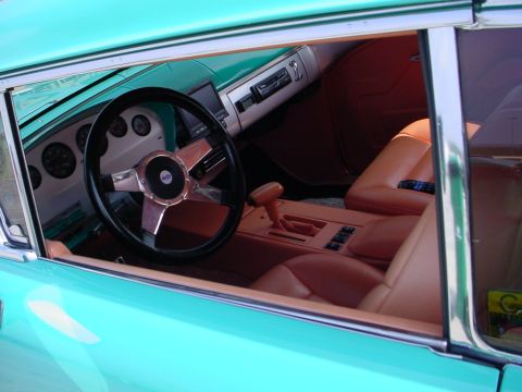1972 Ford Ranchero - The interior of a teal car features tan leather seats and an aftermarket steering wheel.