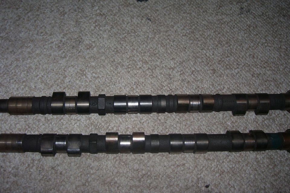 Two camshafts on a carpeted surface