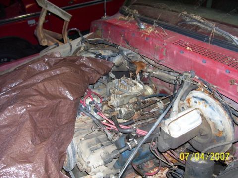 1979 Ford Bronco - Engine bay of a red vehicle, partially covered by a brown tarp. Date stamp reads 07/04/2007.