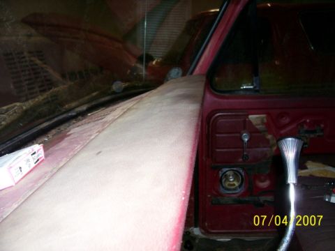 1979 Ford Bronco - Interior view of a red vehicle, possibly a 1978 model, with the door panel removed and a dusty hood.