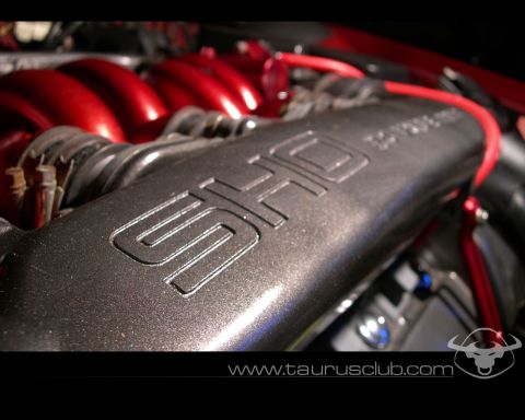 1992 Ford Taurus - Tight close-up of a Ford SHO V6 intake manifold in an engine bay, with the raised 'SHO' lettering on a metallic-gray painted plenum and can…