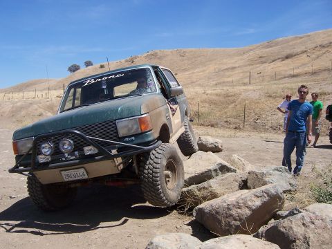 1991 Ford Bronco - This modified Ford Bronco is navigating a rocky obstacle course on a sunny day.