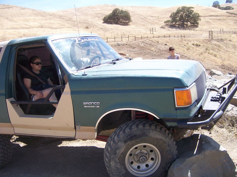 Green 1991 Ford Bronco with off-road tires and custom bumper