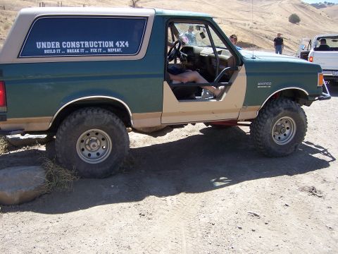 1991 Ford Bronco - This 1991 Ford Bronco, seen off-road, features large tires and a custom "Under Construction 4x4" decal on the rear window.