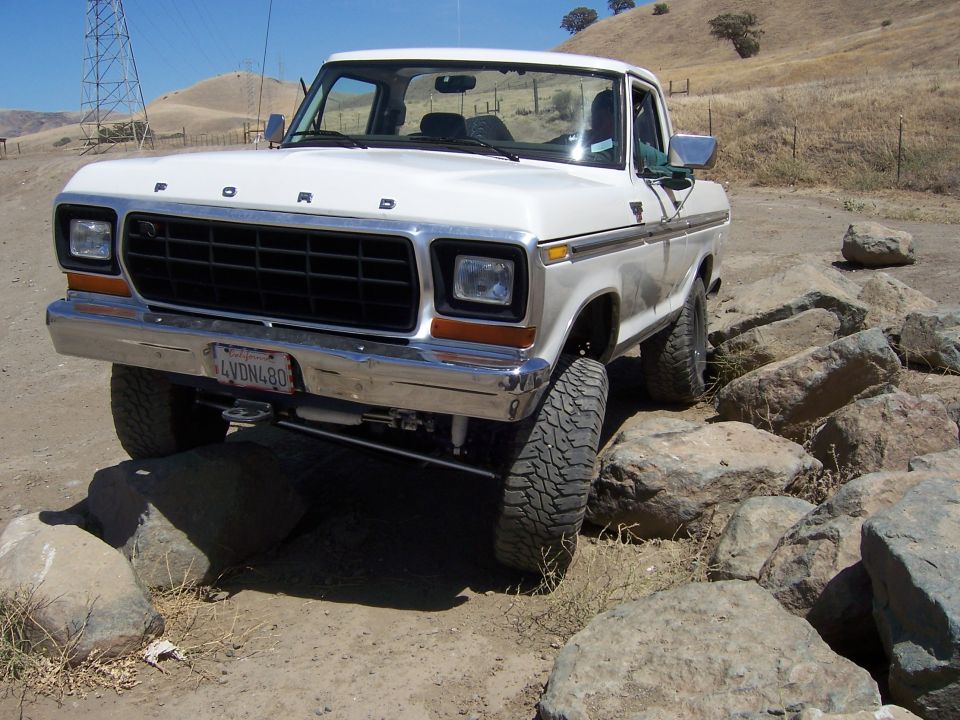 White Ford pickup truck navigating rocks
