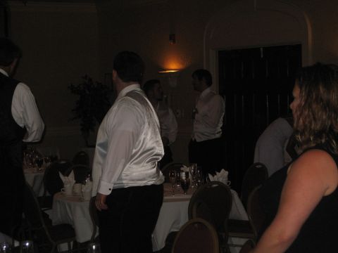 1988 Ford Bronco - A wedding reception scene with guests in formal attire gathered around tables in a dimly lit room.