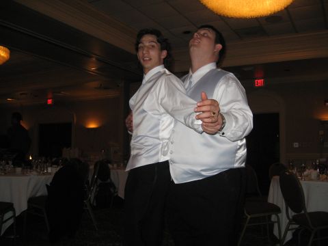 1988 Ford Bronco - Two men in white shirts and vests dance at a formal event, possibly a wedding reception.