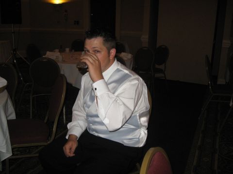 1988 Ford Bronco - A man in formal attire sips a drink while seated at a table during an event.