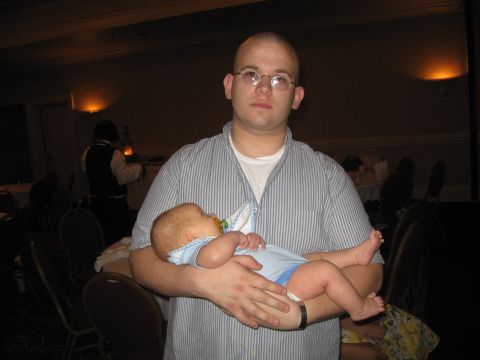 1988 Ford Bronco - A man holds a baby in a dimly lit room with tables and chairs visible in the background.