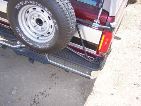 1991 Ford Bronco - Rear view of a maroon and silver SUV, identified as a 1991 Ford Bronco, with a spare tire mounted externally.